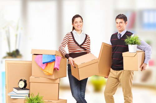Removalists handling furniture in a Manor Park flat with narrow access